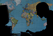 Man using computer against world map