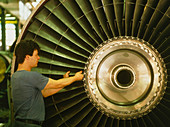 Technician assembles part of a jet engine