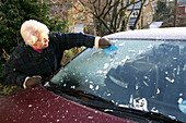 Scraping ice off a car windscreen
