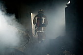 Fire fighter in a burnt house
