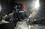 Firefighter in a burnt-out house