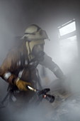 Firefighter carrying a hose