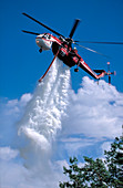 Helicopter drops water over forest fire