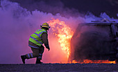Firefighter tackling a burning car