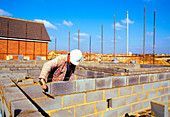 Bricklayer constructing a wall from breeze-blocks