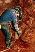 Worker laying explosives in uranium mine