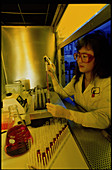 Female chemist filling a test tube with a pipette