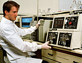 Technician operating HPLC chromatography equipment
