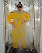 Pharmaceutical worker in isolation suit shower