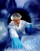 Technician reaching into a pill coating machine