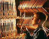 Worker with brass tubing during manufacture