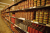 Rows of tinned foodstuffs on supermarket shelves
