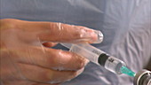 Nurse's hands filling syringe