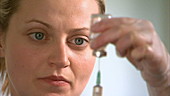 Nurse filling syringe with liquid