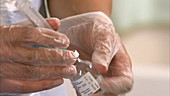 Nurse filling syringe with liquid
