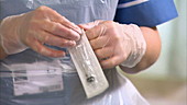 Nurse unwrapping syringe and needle