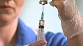 Nurse filling syringe with liquid