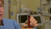 Doctor filling syringe from vial