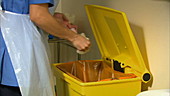 Nurse putting rubbish in yellow bin