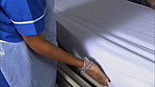 Nurses making hospital bed