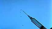 Liquid squeezed from syringe in slow mo