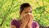 Woman blowing her nose outside