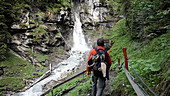 Hiker walking down to waterfall