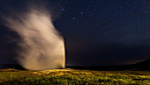 Old Faithful geyser at night