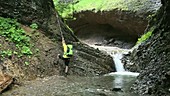 Man rock climbing by waterfall