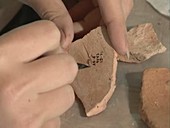 Archaeologist marking artifact