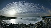 Moonset and daybreak over sea