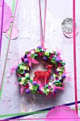 Hand-made door wreath with stag figurine and pink ribbon