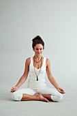 A woman sitting in a lotus position (power yoga)