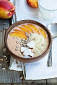 Smoothie bowl with peach, mango, banana, coconut and sunflower seeds