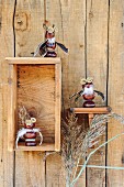 Figurines made from horse chestnuts on rustic wall bracket and in wooden box mounted on board wall