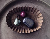 An emerald, a ruby and a sapphire in a vintage bowl