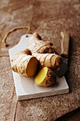 A ginger root on a wooden chopping board