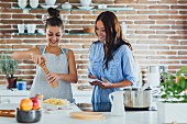 Two young women cooking pasta in a kitchen