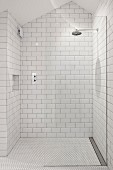 White-tiled shower area with rainfall shower in attic bathroom