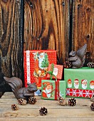 Kreativ verpackte Geschenke mit Weihnachtsmann-Bildern und Eichhörnchen aus Metall
