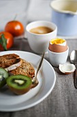 Frühstück mit weichem Ei, frischen Früchten, Toast und Kaffee