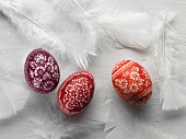 Sorbian Easter eggs and white feathers on a white surface