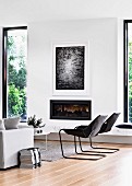 Lounge area with cantilever chair next to gas fireplace and window elements with black frames