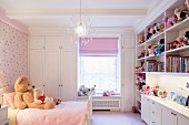 Collection of soft toys on fitted shelves in pink child's bedroom