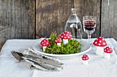 Moss and hand-made toadstool ornaments on plate