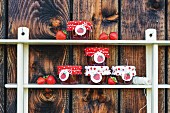 Jars of strawberry jam with polka-dot fabric covers and labels