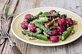 Beetroot gnocchi with green asparagus, walnuts and sage