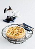 Shortcrust apple cake with slivered almond on a cake stand