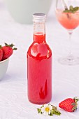 Eine Flasche Rhabarber-Erdbeer-Sirup