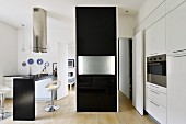 Black partition with folded-up table top in minimalist designer kitchen